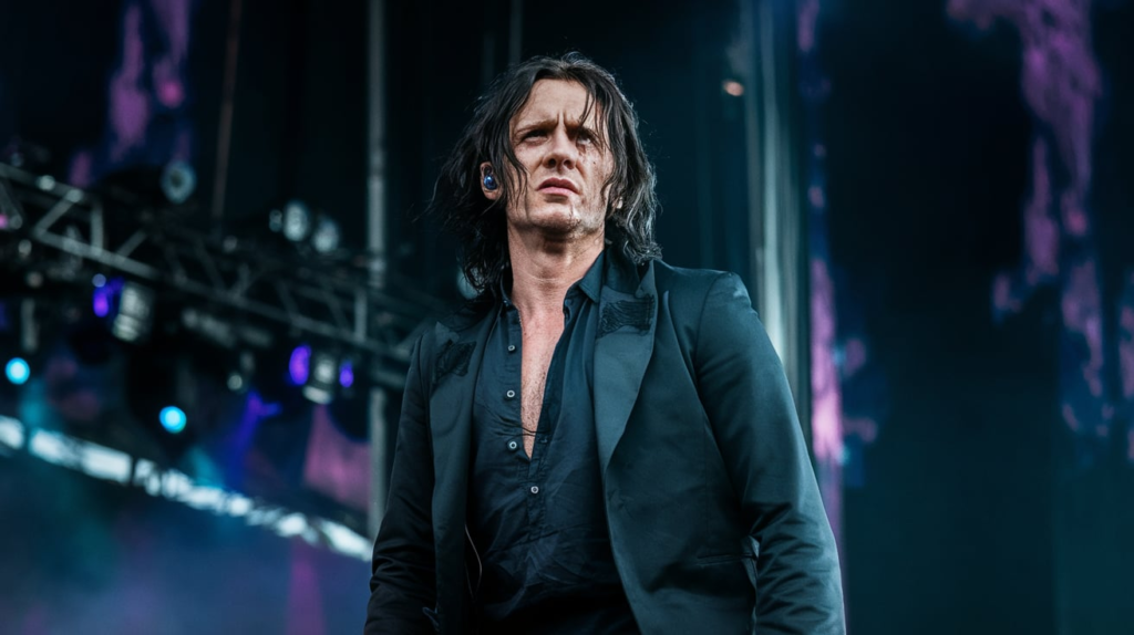 Screengrab of Lewis Capaldi from “Survive” music video walking alone in rain