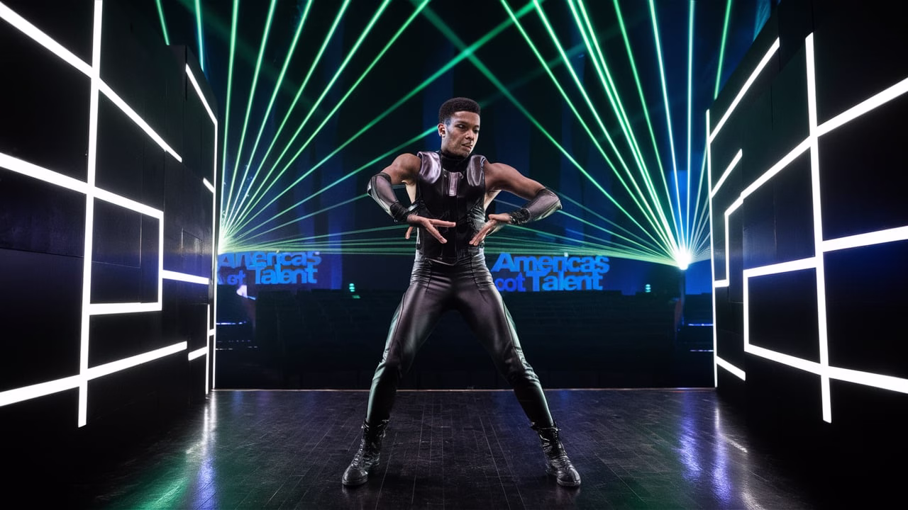 Gendai performing a laser dance on AGT 2025 stage, interacting with vibrant beams of green and blue light